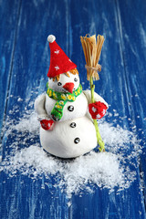 Beautiful snowman  on blue wooden background