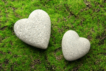Obraz premium Grey stones in shape of heart, on grass background