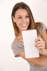 Cheerful girl on white background holding leaflet for message
