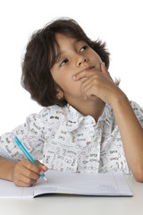 Little boy is thinking about his writing