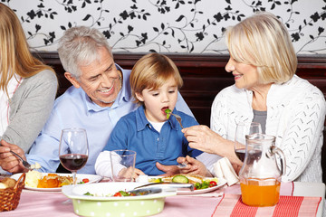 Grandparents feeding grandson at dinner