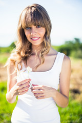 Smiling pretty blonde holding dandelion