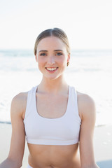 Cute brunette woman sitting on the beach