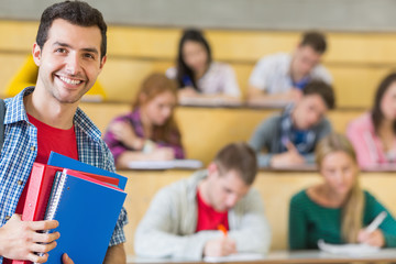 Fototapeta na wymiar Smiling male with students sitting at the lecture hall