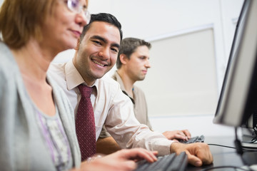 Teacher and mature students in computer room