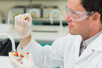 Male scientist analyzing pills in the laboratory