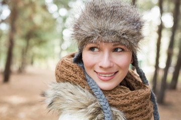 Woman in fur hat with woolen scarf in the woods