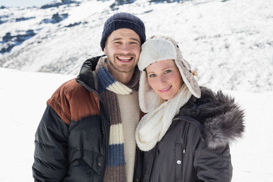 Couple in warm clothing standing on snowed landscape