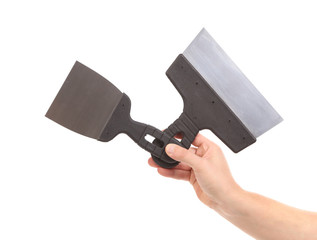 Hand holds two construction spatula.