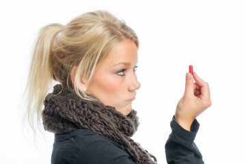 Blonde Frau hält eine Grippekapsel
