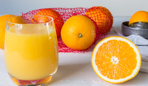Orangensaft im Glas und Orange