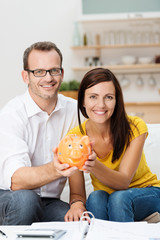 paar mit sparschwein und unterlagen zu hause