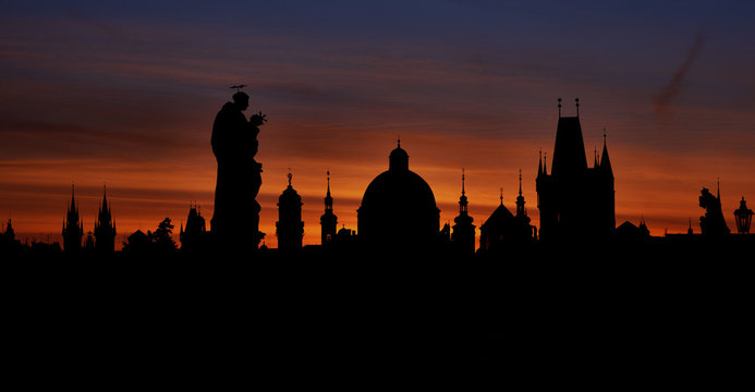 Prague silhouettes from Charles Bridge before dawn