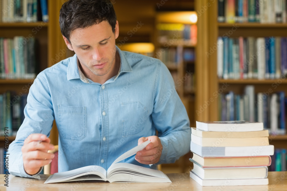 Wall mural Serious mature student studying at library desk