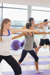 Fototapeta premium Sporty people stretching hands at yoga class in fitness studio