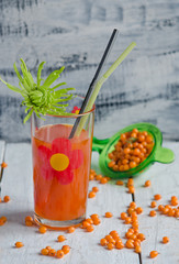 Sea buckthorn berries juice on the glass wiyh flower