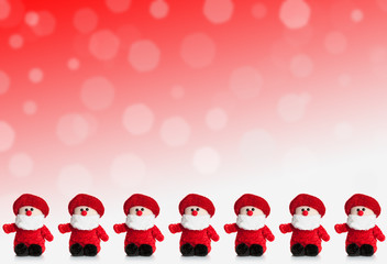Row of puppets of Santa Claus on a red background with snow