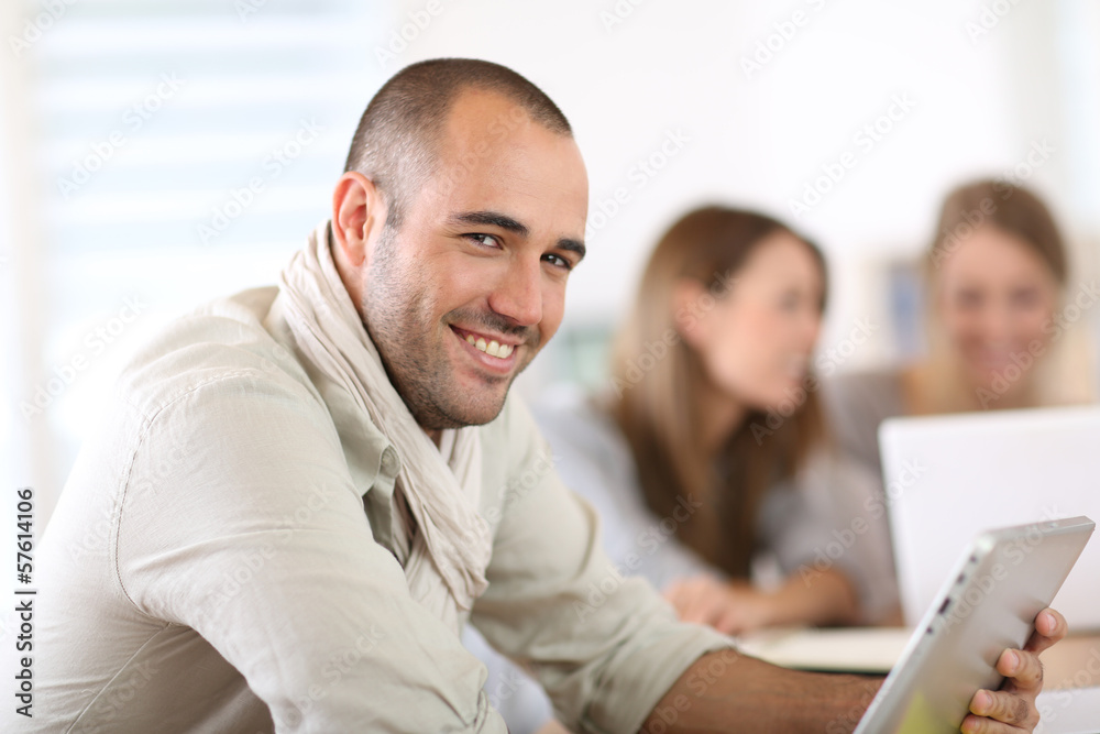 Aufkleber Smiling man in office using digital tablet
