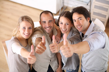 Business team showing thumbs up