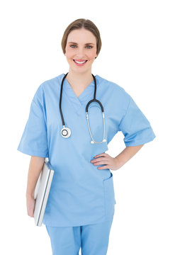 Young female doctor holding a notebook and smiling into the came
