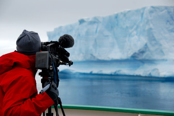 Obraz na płótnie Canvas cameraman films an iceberg in antarctica