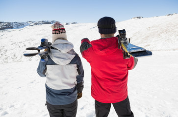 Fototapeta na wymiar Rear view of a couple with ski boards on snow