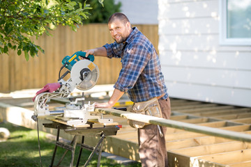 Carpenter Cutting Wood Using Table Saw At Site