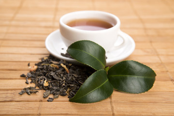 A cup of green tea with freh leaves