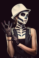 Woman with skeleton face art over black background