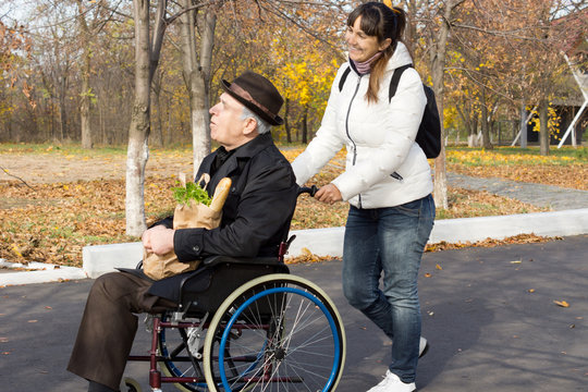 Happy woman helping a disabled elderly man