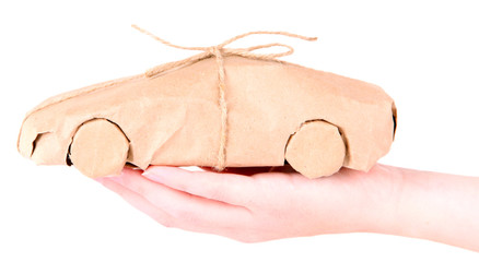 Woman hand holding a car wrapped in brown kraft paper, isolated