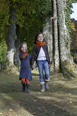 Fototapeta premium two girls walking on a path in the forest
