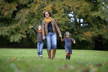 Fototapeta premium Mother and children walking in the park
