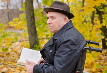 Pensive man reading outdoors in autumn