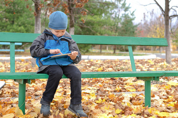 Fototapeta premium Cute little boy surfing on his tablet computer