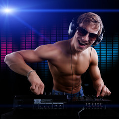Sexy DJ macho is playing disco music in headphones