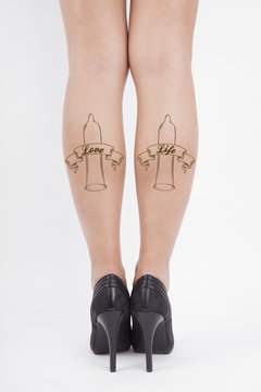 woman's leg with a condom tatoo
