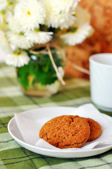 Still life of home-baked oatcakes, tea, and chrysanthemums