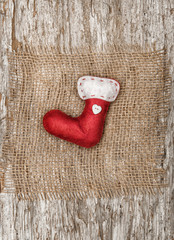 Red sock with the burlap textile on the old wood