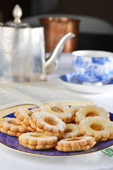 Delicious jam cookies with cup of English tea and book