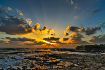 Sunset over the sea and stony coast