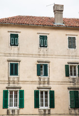 Naklejka premium Old Building in Kotor with Green Shutters