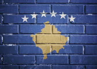 Kosovo flag on a textured brick wall