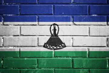 Lesotho flag on a textured brick wall