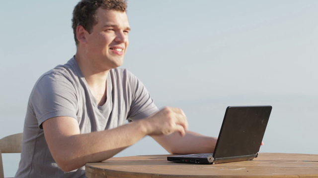 Man typing on a small laptop computer