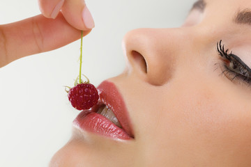 Beautiful woman eating sweet raspberries,close up