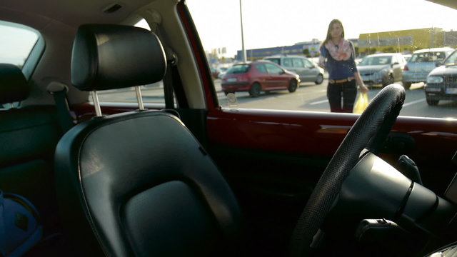young girl getting in a car with a yellow shopping bag