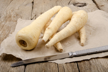 parsnip lie with a knife on brown paper