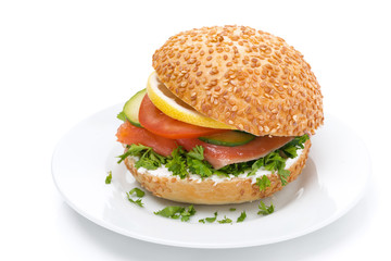 burger with smoked salmon and vegetables on the plate, isolated