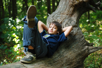 Boy with a gadget in the forest